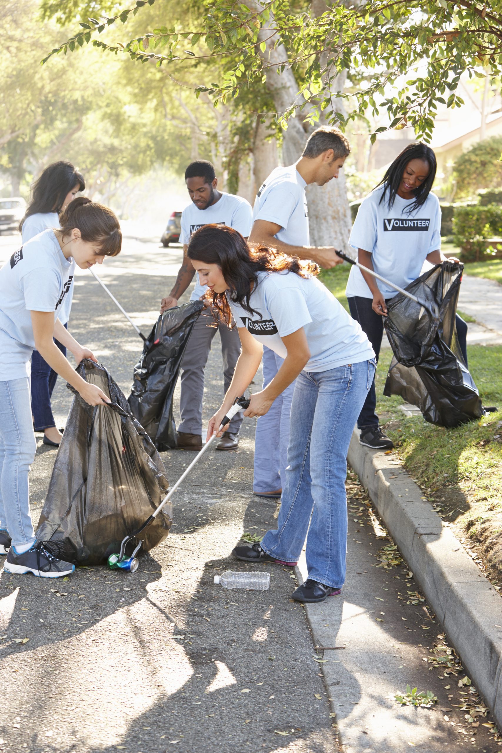 Team Of Volunteers Picking Up Litter In Suburban Street